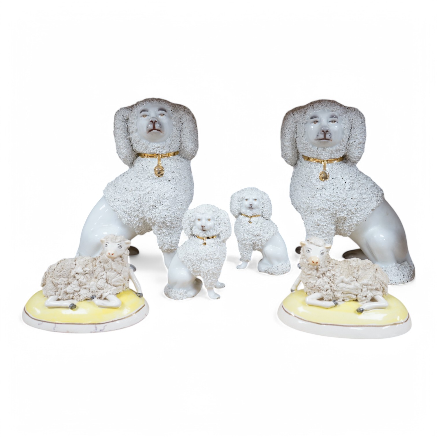 A pair of Continental porcelain models of Poodles a similar smaller pair and a pair of late Staffordshire sheep. Large poodles 23cm high. Condition - one leg on large Poodle broken and reglued